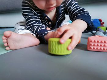 Midsection of boy playing with toy blocks