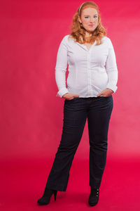 Portrait of smiling woman against pink background