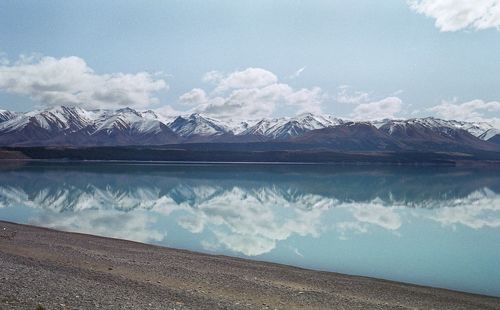 Scenic view of lake and snowcapped mountains against sky