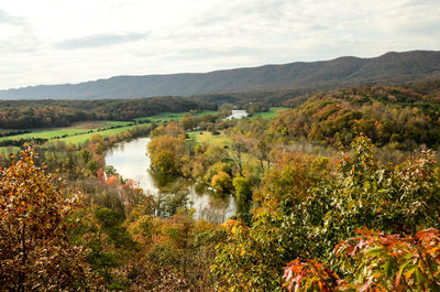 Scenic view of river by mountain against sky