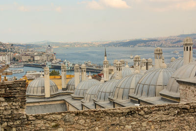 High angle view of domes and buildings by strait against sky