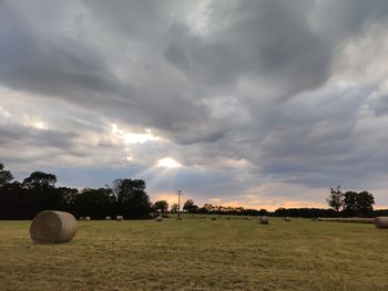 Hay bales on field against sky