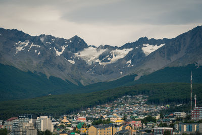 Aerial view of townscape and mountains against sky