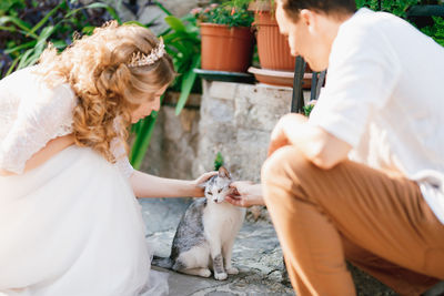 Young couple stroking cat outdoors
