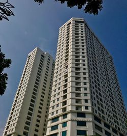 Low angle view of modern buildings against blue sky