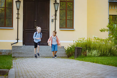 Full length of boy walking on footpath