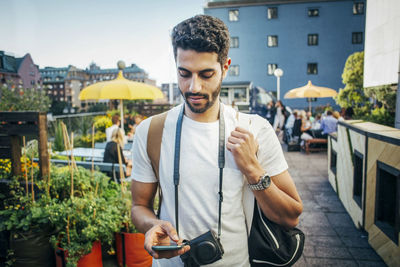 Male tourist using smart phone in city