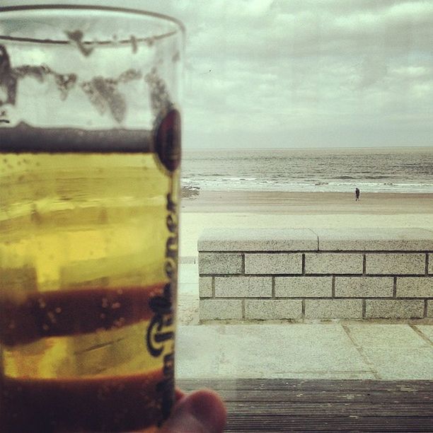 water, glass - material, transparent, drink, refreshment, sky, window, glass, sea, horizon over water, reflection, drinking glass, food and drink, wet, focus on foreground, indoors, close-up, cloud - sky, freshness, beach