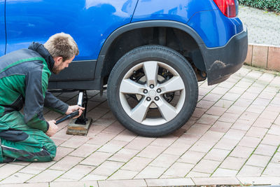 Side view of mechanic repairing car