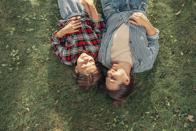 High angle view of young woman sitting on grassy field