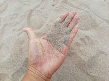 Close-up of hand on sand