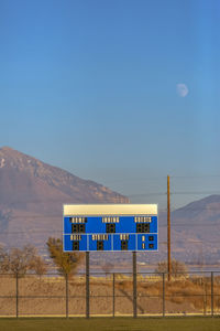Information sign on field against blue sky