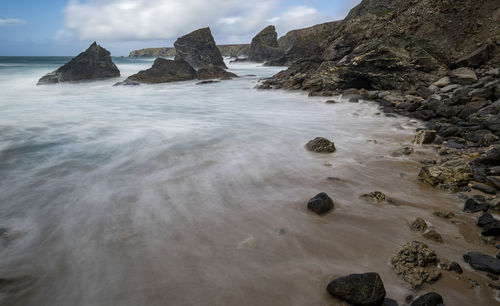 Rocks on beach against sky