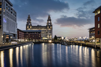 Reflection of illuminated buildings in city at waterfront