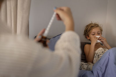 Mother applying medicine to sick boy