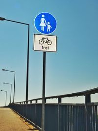 Road sign against clear blue sky