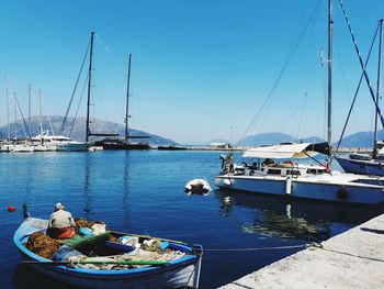 Sailboats moored in harbor