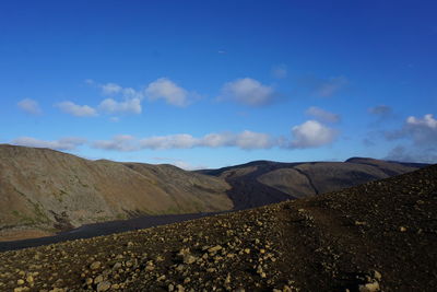 Scenic view of landscape and mountains against blue sky