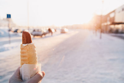 Close-up of hand holding food in city