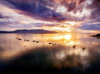 Scenic view of sea against cloudy sky during sunset