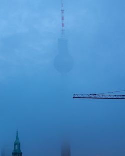 Fernsehturm against sky during foggy weather