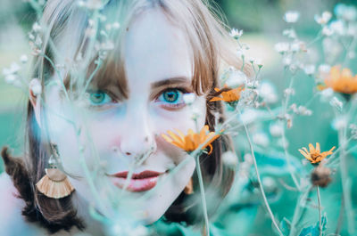 Close-up of beautiful woman looking through plants