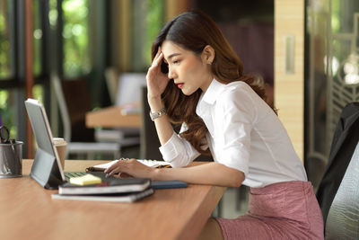 Woman working while sitting at cafe