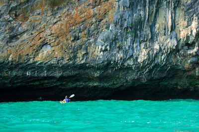 Man surfing on rock in sea