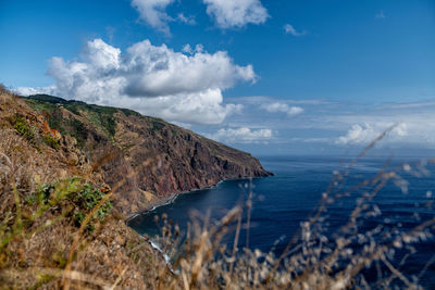 Scenic view of sea and mountains against sky