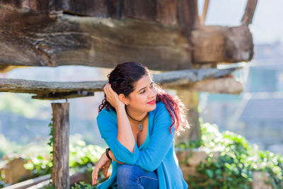 Young woman standing against tree