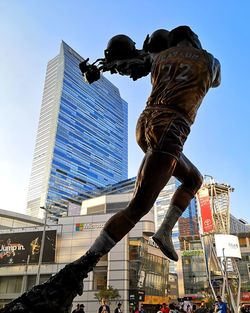 Low angle view of sculpture against buildings in city