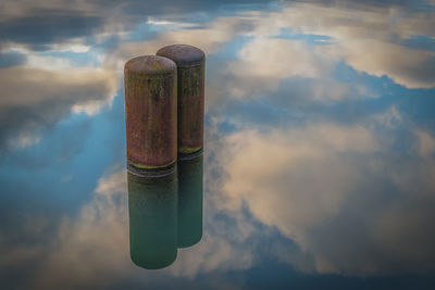 Close-up of metallic structure in lake against sky