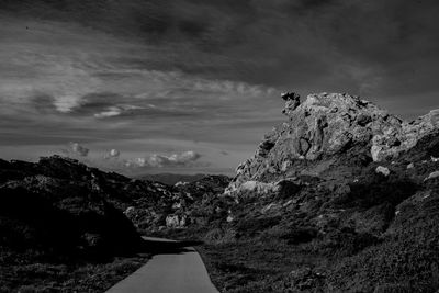 Road amidst rocks against sky