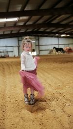 Full length of cute girl with pink petals on floor