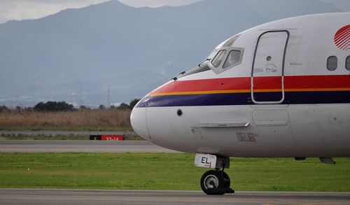 Airplane on airport runway against sky