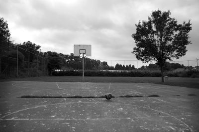 Basketball hoop on field against sky