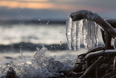 Close-up of icicles against sky during winter