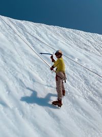Full length of man ice climbing on glacier 