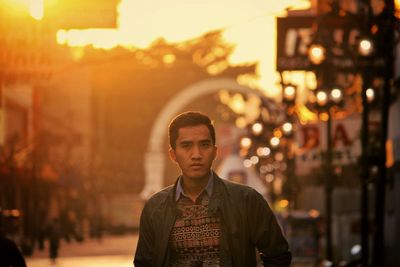 Portrait of young man in city at night