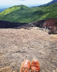 Low section of person standing on landscape against sky