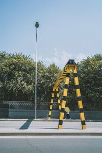 Road sign by street against sky