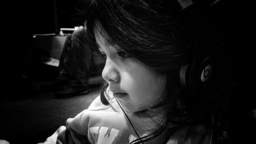 Close-up of girl listening music while traveling on vehicle