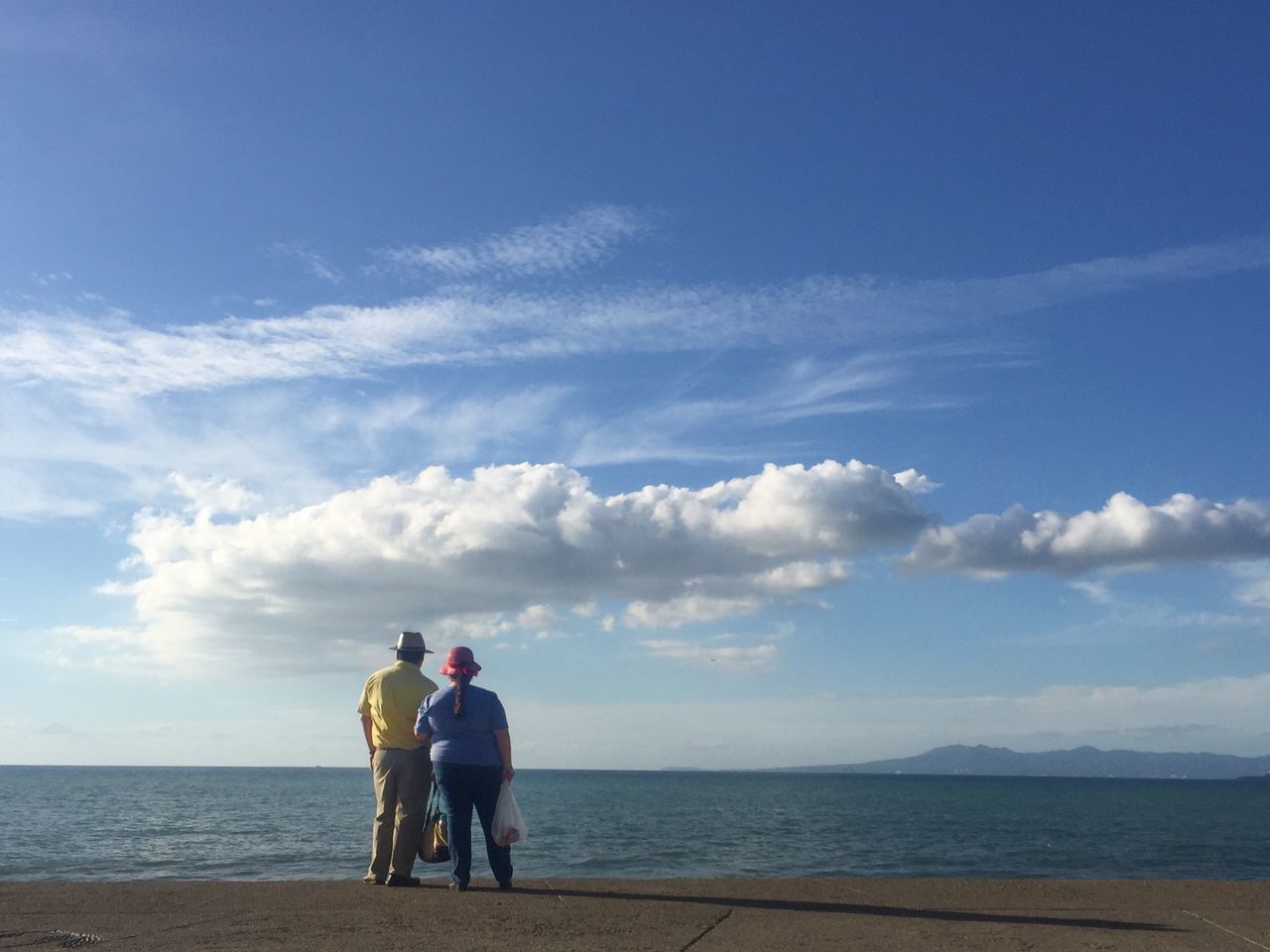 sea, horizon over water, water, beach, sky, lifestyles, leisure activity, shore, men, togetherness, rear view, tranquility, full length, scenics, beauty in nature, tranquil scene, standing, nature