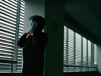 Low angle view of man standing against window