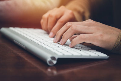 Midsection of man using laptop on table