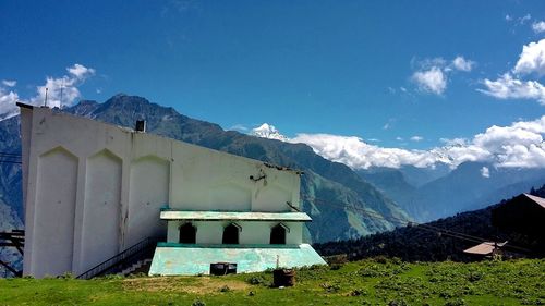 Exterior of houses in front of church against blue sky