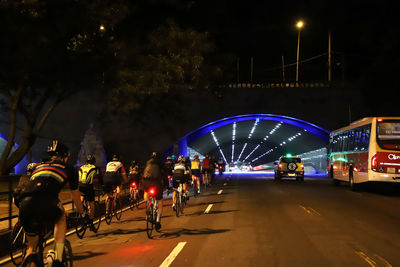 People on illuminated street at night