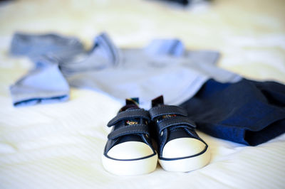 Close-up of black shoes on bed