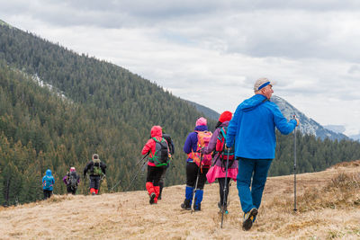 Rear view of people walking on mountain