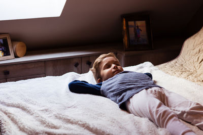 Cute boy sleeping on bed at home